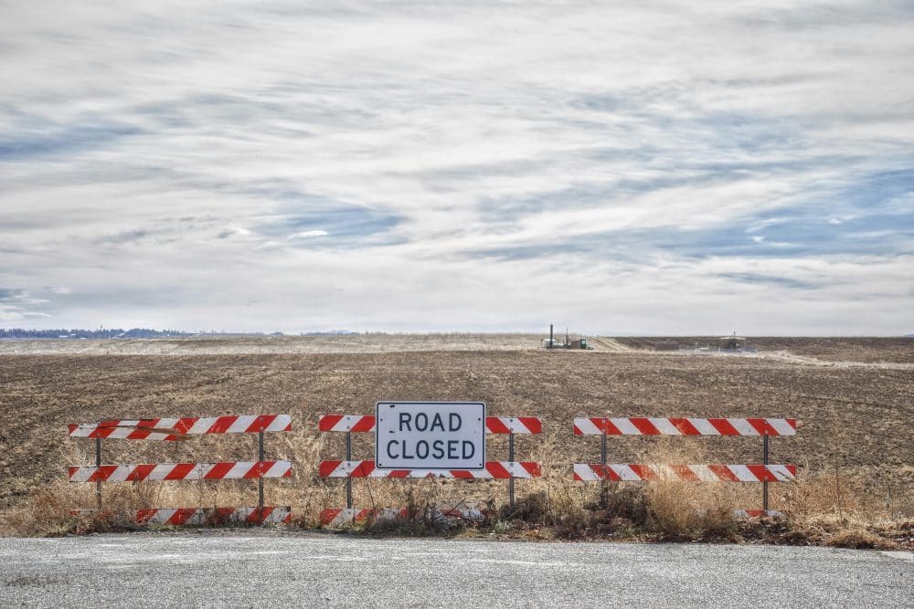 Road closed sign blocking an empty street, symbolizing a decision point