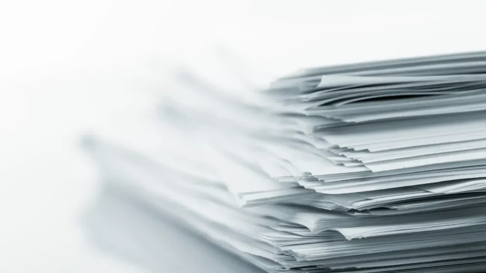 Stack of documents representing professional background checks and due diligence